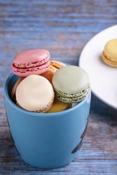 Stacked macarons of different flavors in a blue mug. Stock-Fotos