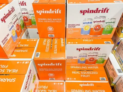 Stacked orange and white boxes of Spindrift Sparkling Water on display in a s Stock Photos