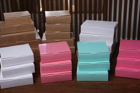 Stacked packaging boxes on wooden table indoors. Production line Stock Photos