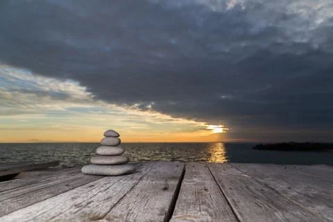 Stacked pebbles and setting sun Stock-Fotos