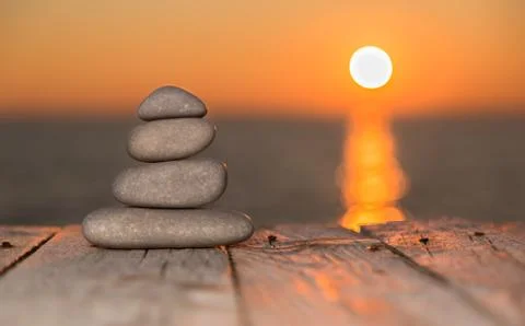 Stacked pebbles and setting sun Foto stock