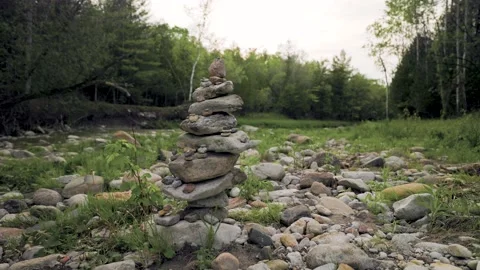 Stacked pile of natural river rocks with big and small stones in a forest Stock Footage 201115627
