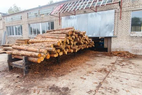 Stacked pine logs outside an old brick sawmill Stock Photos