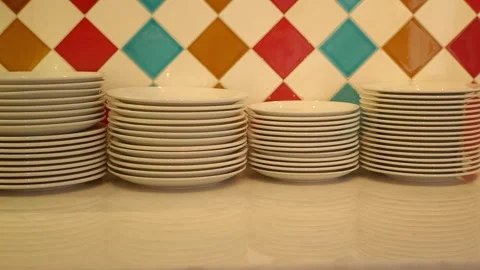 Stacked plates on a table with colorful background Stock Footage 314089964