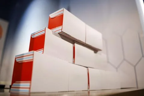 Stacked red and white boxes on a shelf in a store Stock Photos