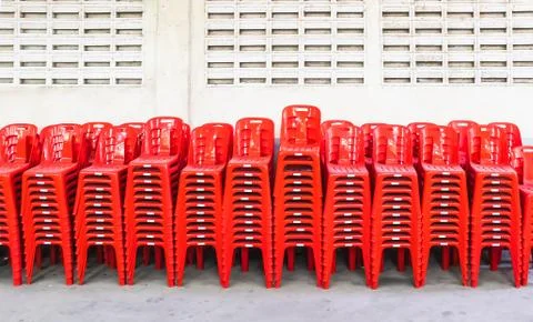 Stacked red plastic chairs in rows, After use Fotos de archivo