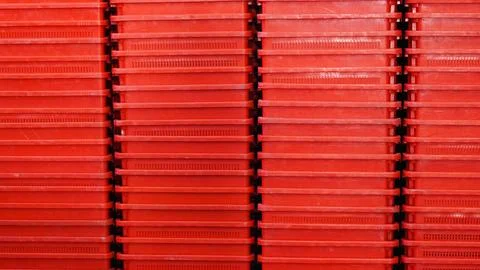 Stacked red plastic containers arranged in a uniform pattern Stock Photos