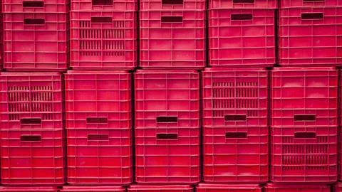 Stacked red plastic storage crates arranged in a grid pattern Stock Photos