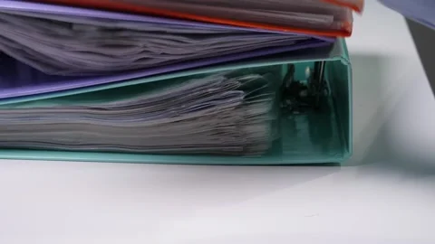 Stacked ring binders, filled with numerous documents, folders, and paper Stock Footage 342760792