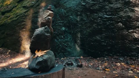 Stacked rocks in front of waterfall in fall in slow motion Stock Footage 255618908