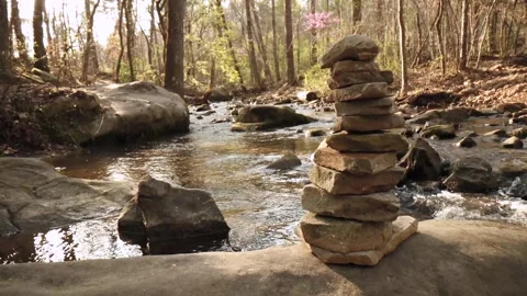 Stacked Rocks Tracking Shot With Softly Sunlit River Flowing Behind 스톡 동영상 315225363