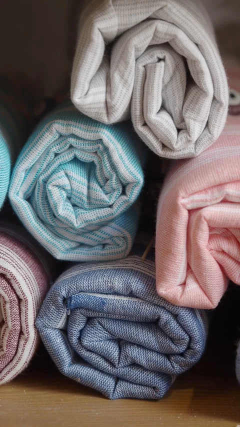 Stacked rolled fabrics in various colors displayed neatly Stock Footage 313772843