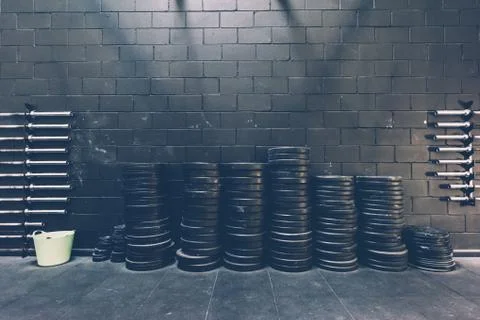 Stacked rows of barbell weights in black gym Stock Photos