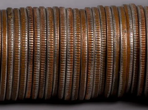 Stacked rows of old coins displayed on a flat surface Stock Photos
