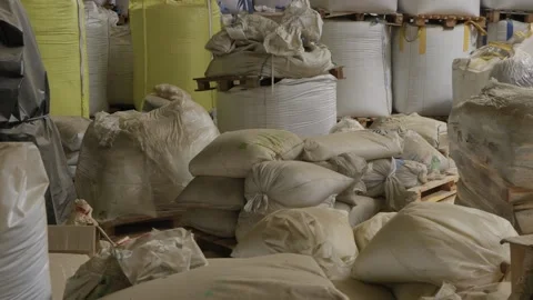Stacked sacks and bulk bags of raw material in factory warehouse Stock Footage 345277214