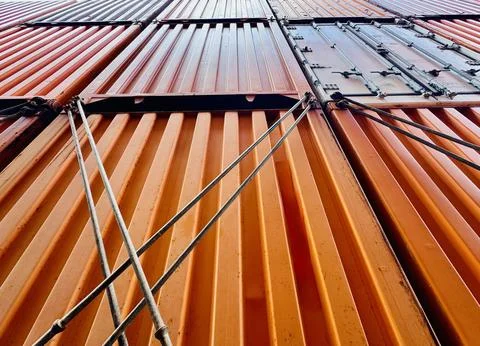 Stacked Shipping Containers Viewed from Below Against Blue Sky Foto stock