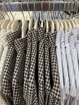 Stacked shirts in various patterns and colors in a retail store setting Stock Photos