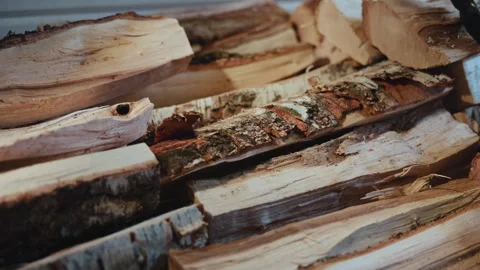 Stacked split firewood logs with rough bark, pale cut surfaces, layered grain Stock Footage 347020283