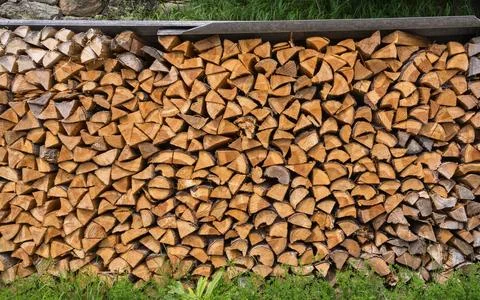 Stacked split logs. Pile of logs ready for winter. Wooden stumps, firewood .. Stock Photos