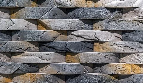 Stacked stone wall with textured bricks. Close-up of a decorative wall made of Stock Photos