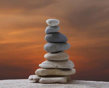 Stacked stones in a pyramid shape on a background on sunset. Foto stock