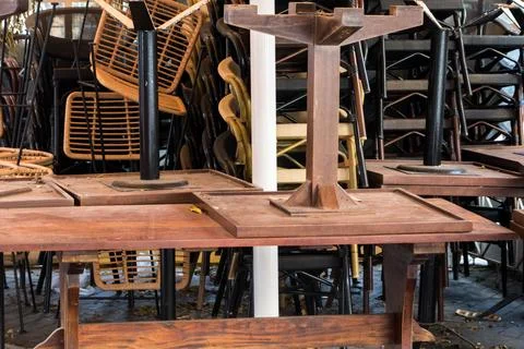 Stacked table seats outside of a closed shop. Stock Photos