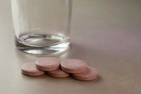 Stacked tablets ready for a refreshing drink beside an empty glass Stock Photos