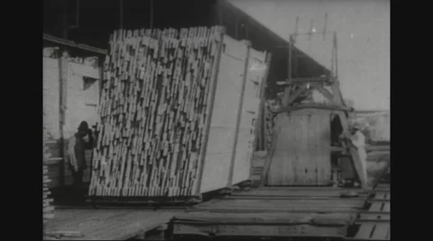 Stacked timber being pushed on wheels in timber yard Stockbeeldmateriaal 43310456