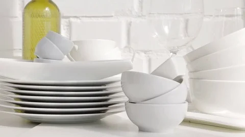Stacked white porcelain dishes, plates in kitchen interior Stock Footage