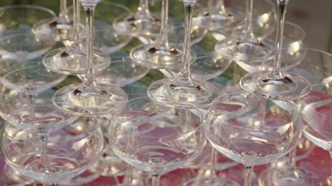 Stacked wine glasses on red table. Banquet preparation setup Stock Footage 304315541