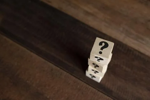 Stacked wooden cube with question mark on table. Stock Photos