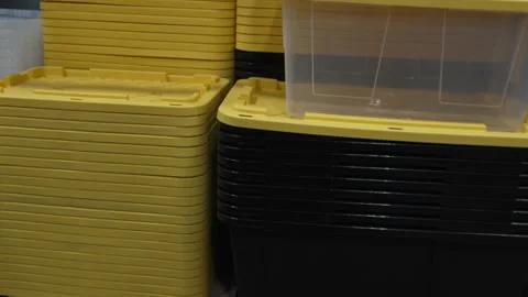 Stacked Yellow Plastic Storage Bin Lids on Wooden Pallets in Warehouse Stock Footage 343348335