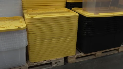 Stacked Yellow Plastic Storage Bin Lids on Wooden Pallets in Warehouse Stock Footage 344363609
