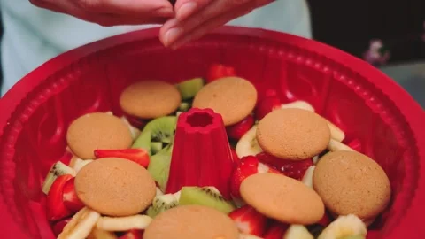 Stacking biscuits on a fruit cake Stock Footage 249461876