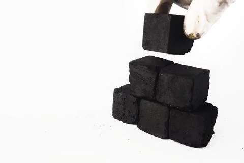 Stacking Black Charcoal Cubes on White Surface with Gloved Hand Stock Photos