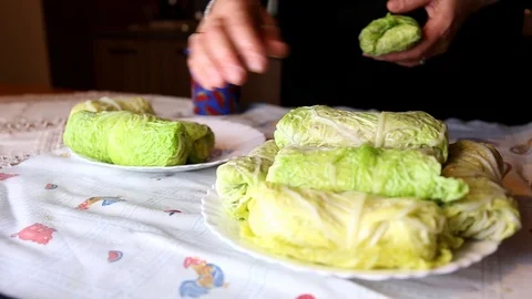 Stacking Cabbage Rolls (Polish golabki) on plates on a table by a woman Stock Footage 119872716