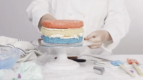 Stacking cake layers to create the round three-layer vanilla cake. Stock Footage 116197342