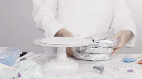 Stacking cake layers to create the round three-layer vanilla cake. Stock Footage 122306528