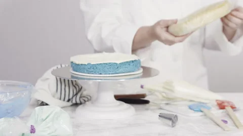 Stacking cake layers to create the round three-layer vanilla cake. Stock Footage 135963502