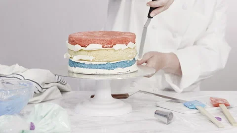 Stacking cake layers to create the round three-layer vanilla cake. Stock Footage 138379021