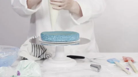 Stacking cake layers to create the round three-layer vanilla cake. Stock Footage 150241096
