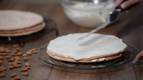 Stacking cake layers. Making torte with buttercream filling Stock Footage 84212137