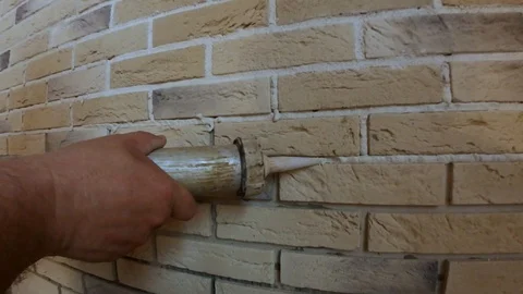Stacking of decorative stone on the wall, restoration of joints between plates u Stock Footage 88777523