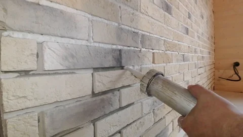 Stacking of decorative stone on the wall, restoration of joints between plates u Stock Footage 88777525
