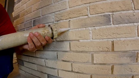 Stacking of decorative stone on the wall, restoration of joints between plates  Stock Footage 89254461