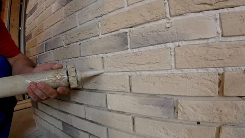 Stacking of decorative stone on the wall, restoration of joints between plates  Stock Footage 89254472
