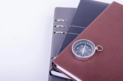 Stacking diaries and compass over white background. Foto stock