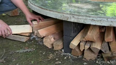 Stacking Firewood Under DIY Outdoor Fire Pit Table Video stock 342630626