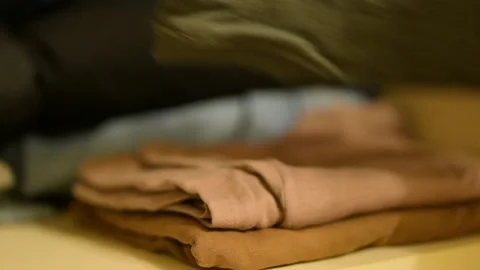 Stacking fresh washed and dried clothes to the wardrobe Stock Footage 280122921
