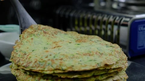 Stacking Green Pancakes on Kitchen Counter Cooking Video stock 341435744